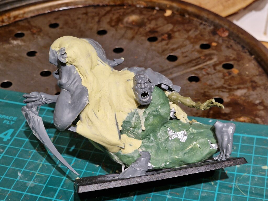 I use green stuff to skin the armature, but milliput to rough out the basic shape