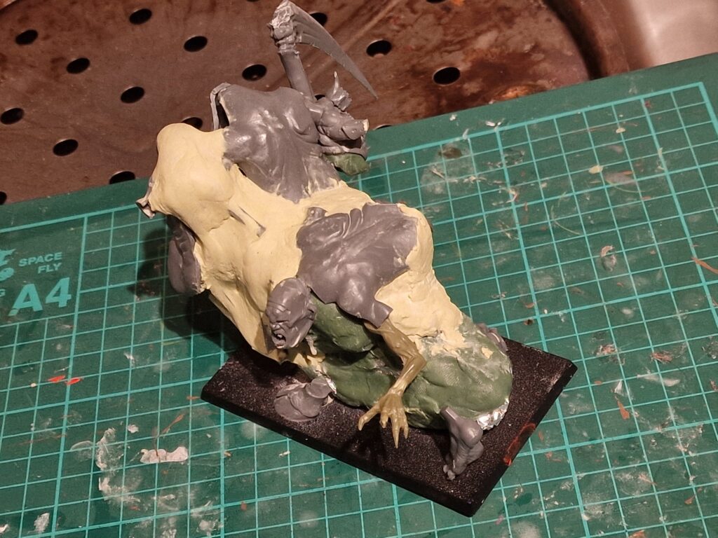 I use green stuff to skin the armature, but milliput to rough out the basic shape, along with some spare parts of miniatures